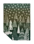 A wool blanket with a forest theme, featuring various tree patterns and stars in shades of green and white, edged with fringe, made by weaving mill Barker Textiles.