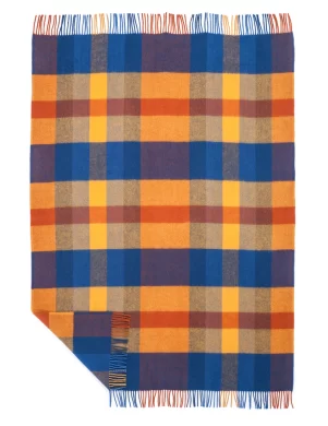 A woven wool blanket featuring a plaid pattern in vibrant blue, orange, and yellow colors with fringe edges, made by weaving mill Barker Textiles.