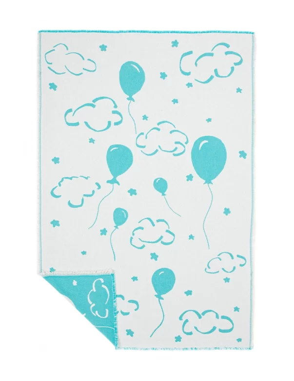 A baby blanket with a cheerful pattern of blue balloons and clouds on a white background made by weaving mill Barker Textiles.