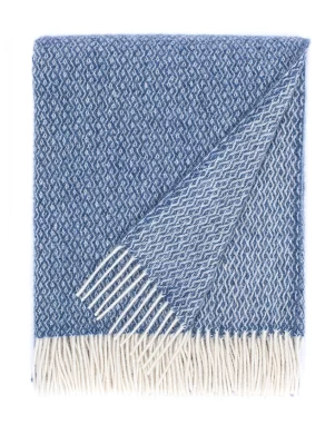 A recycled wool blanket with a braided pattern in gray and white, finished with white fringes, made by Barker Textiles.