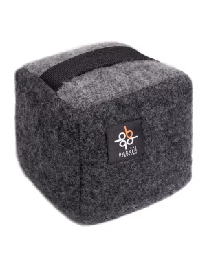 Gray doorstop cube with a black handle and a Barker Textiles label made by weaving mill Barker Textiles.