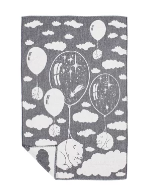 A grey baby blanket with a whimsical design of dreaming bears floating with balloons among the clouds made by weaving mill Barker Textiles.