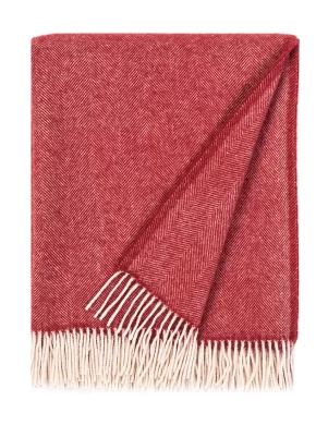 Red wool blanket with a chevron pattern, complete with white fringe edges, made by weaving mill Barker Textiles.