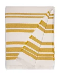 A white cotton blanket with mustard yellow horizontal stripes and a textured weave, featuring fringed edges, made by weaving mill Barker Textiles.