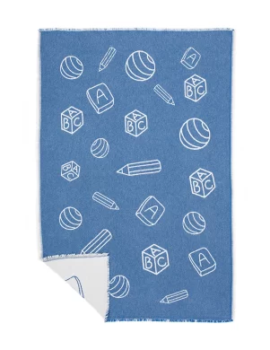 A blue baby blanket decorated with white drawings of pencils, balls, and ABC blocks, ideal for young childrenmade by weaving mill Barker Textiles.