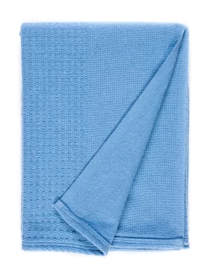 A white blanket with a folded corner, displaying a blue decorative stripe along one edge made by weaving mill Barker Textiles.